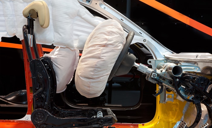 A vehicle with the airbag puffed out, but you can see the internals underneath the dashboard