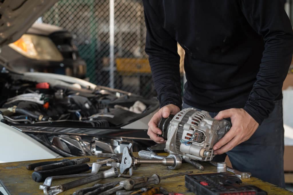 A man repairing an alternator