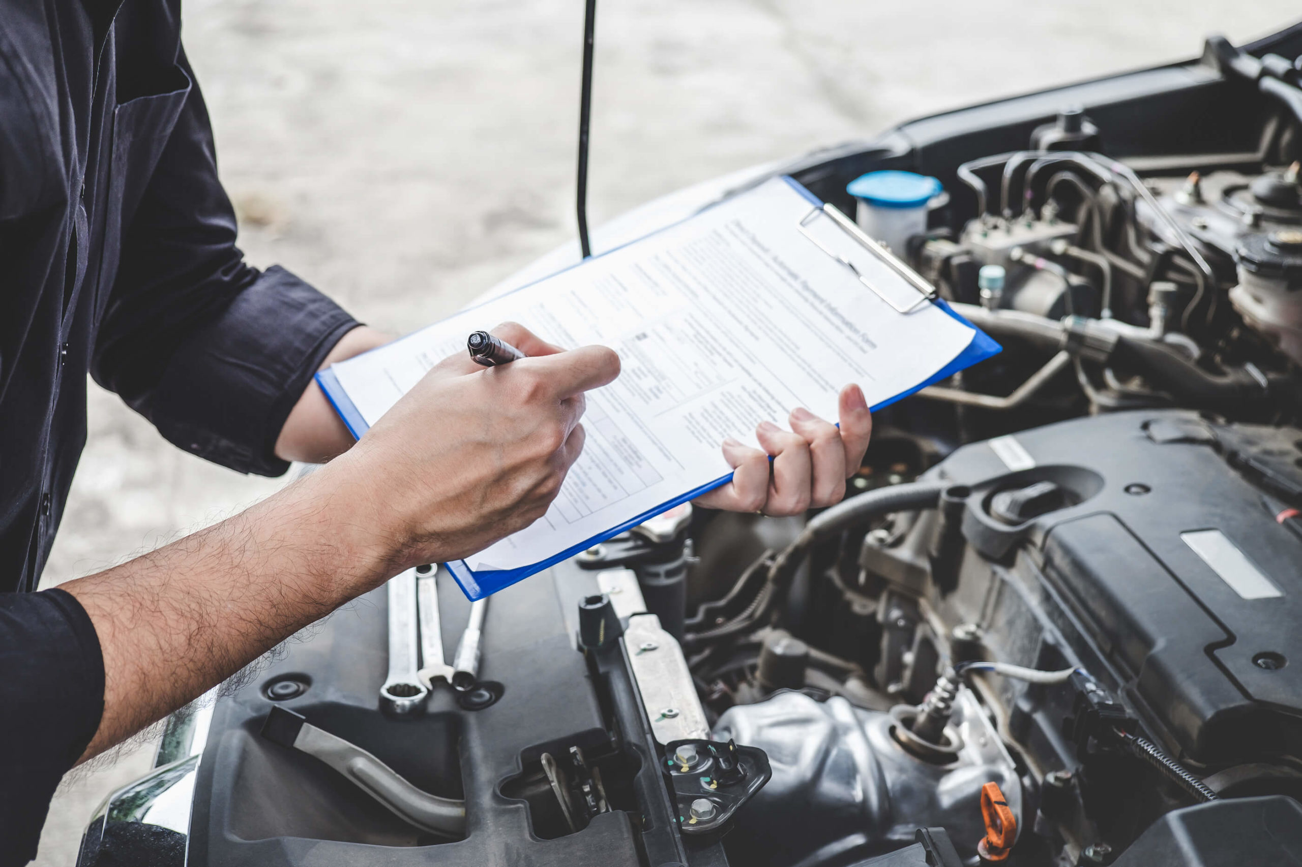 Someone taking notes next to a vehicle