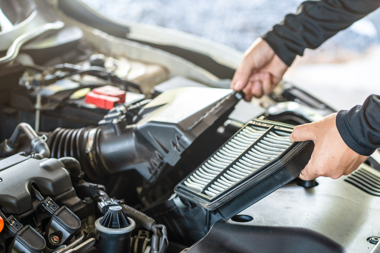 An automotive technician replacing an engine's air filter