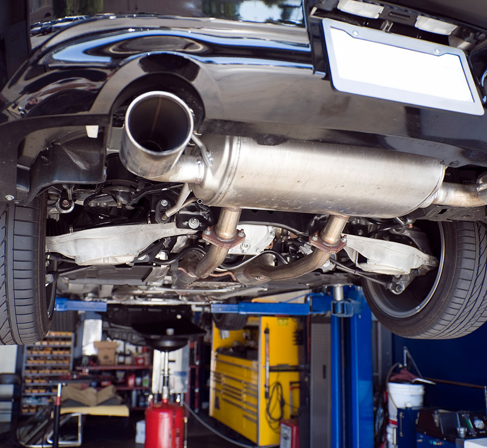 The back-view of a vehicle on a lift showing the exhaust system