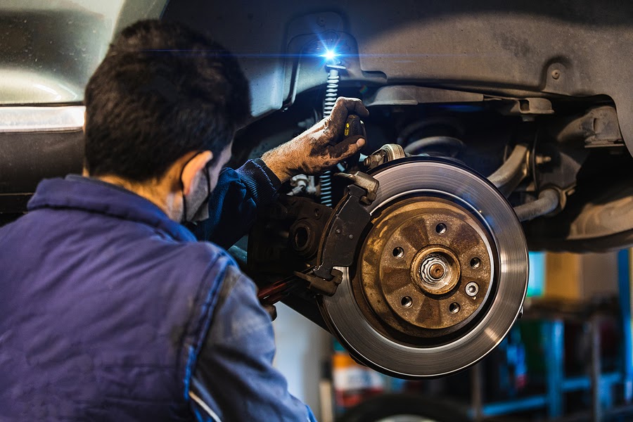 An automotive technician inspecting a vehicle's suspension system