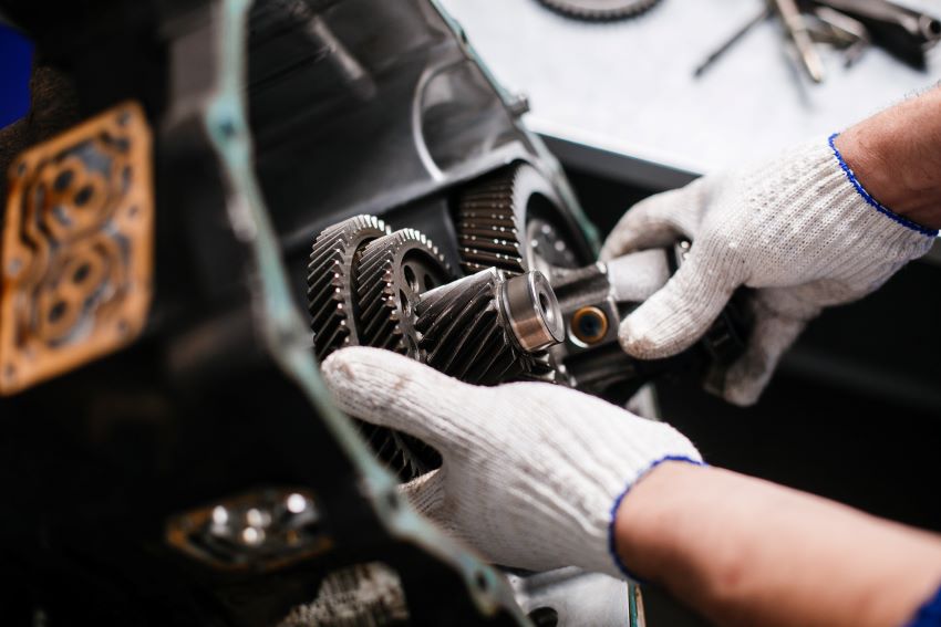 An experienced automotive technician servicing a transmission