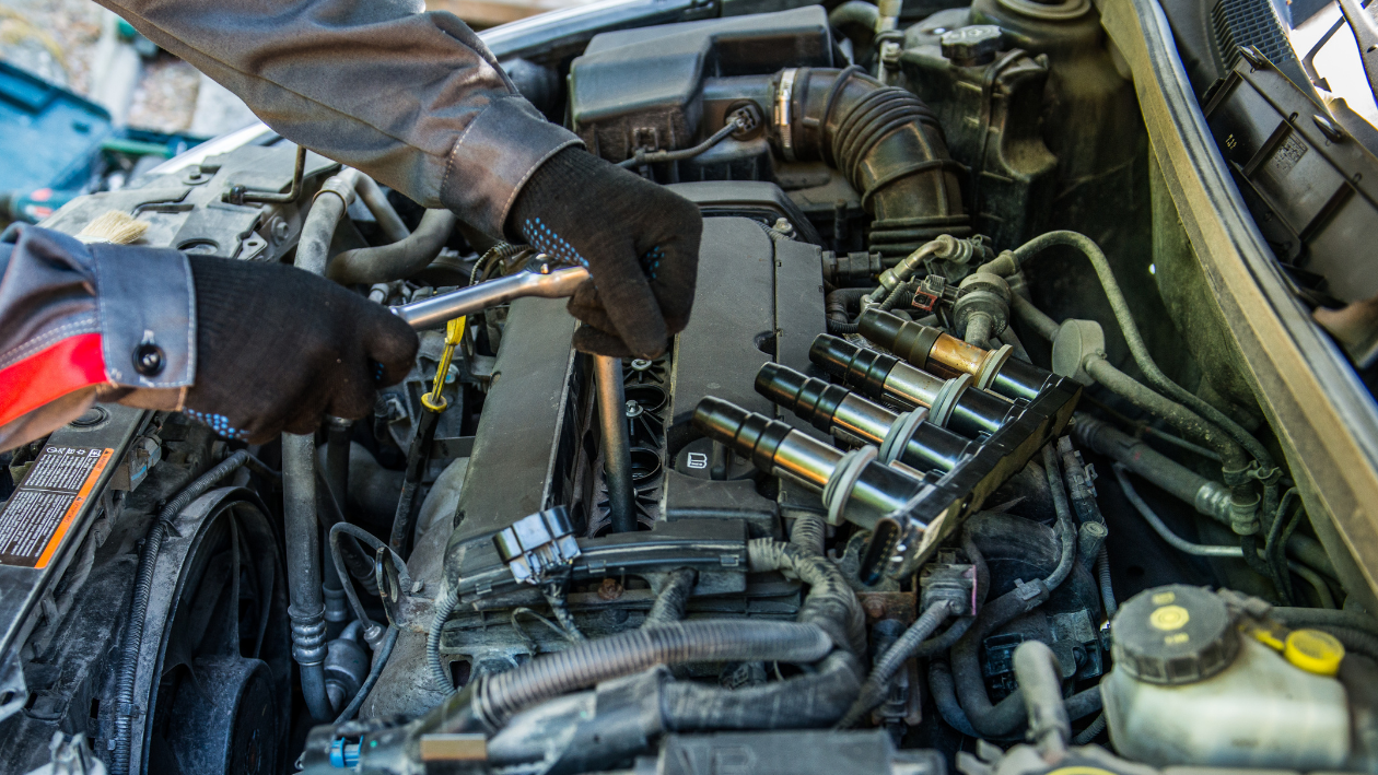 An automotive technician changing spark plugs