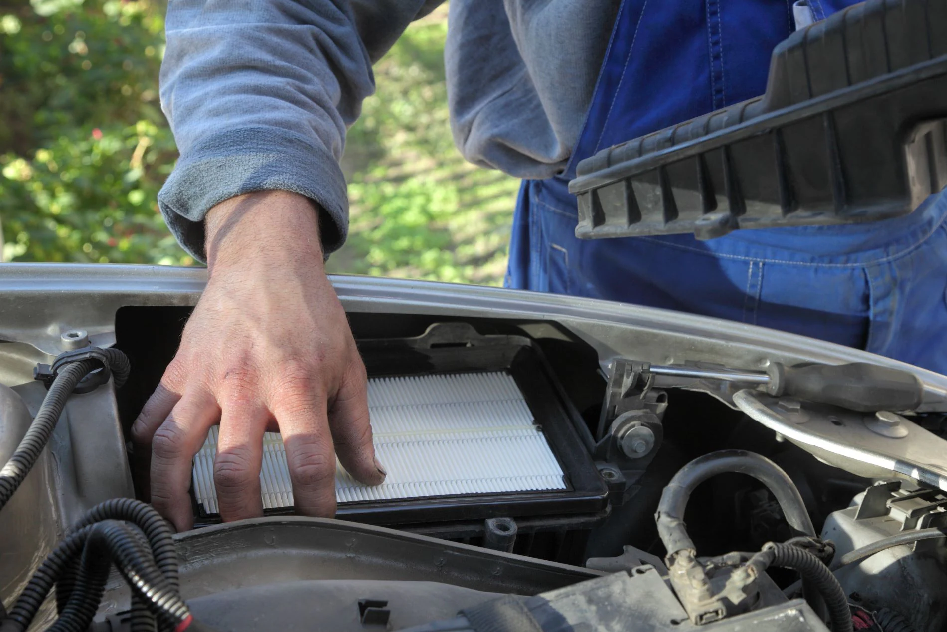 An automotive technician replacing an air filter